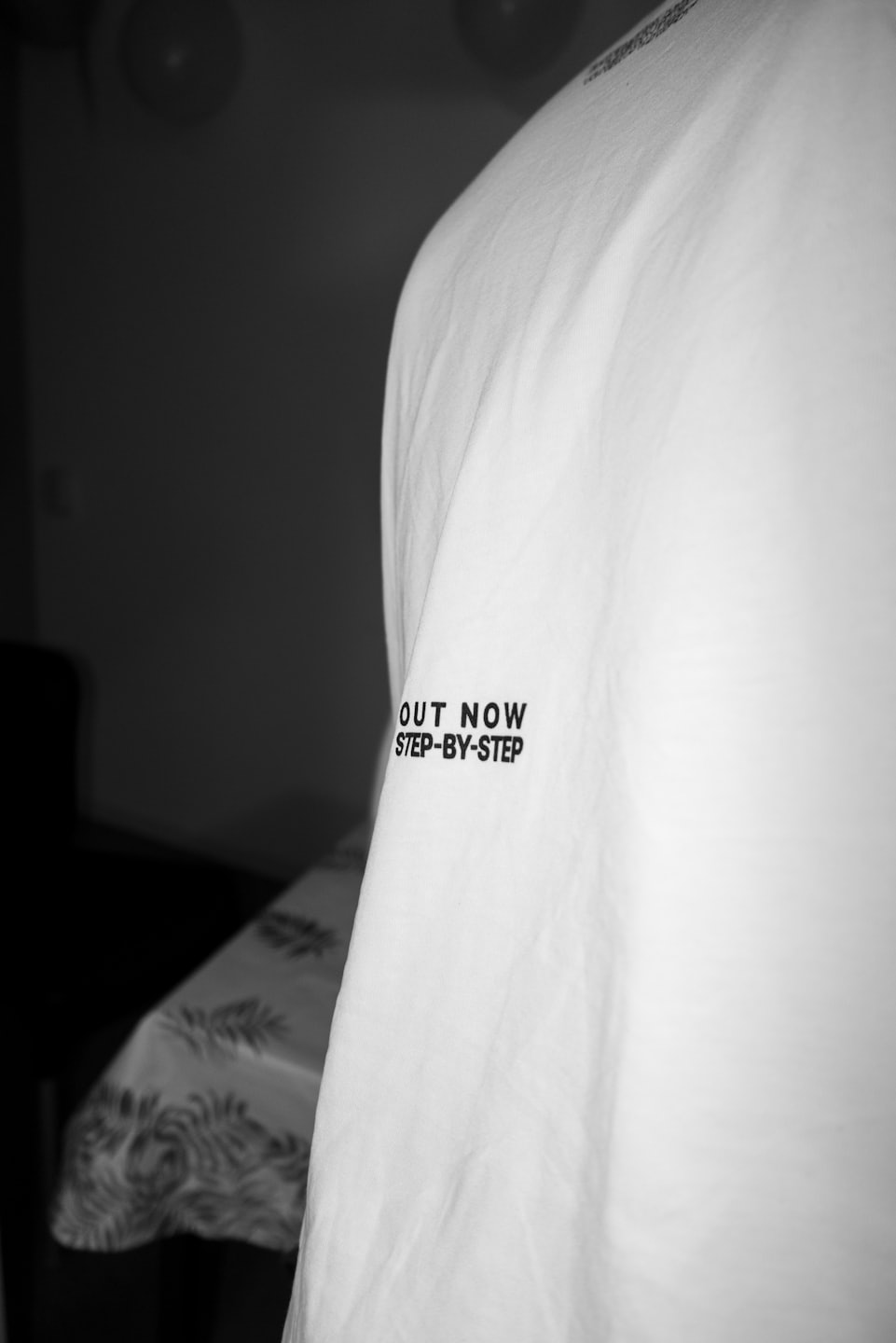 Black text printed on a white t-shirt sleeve.