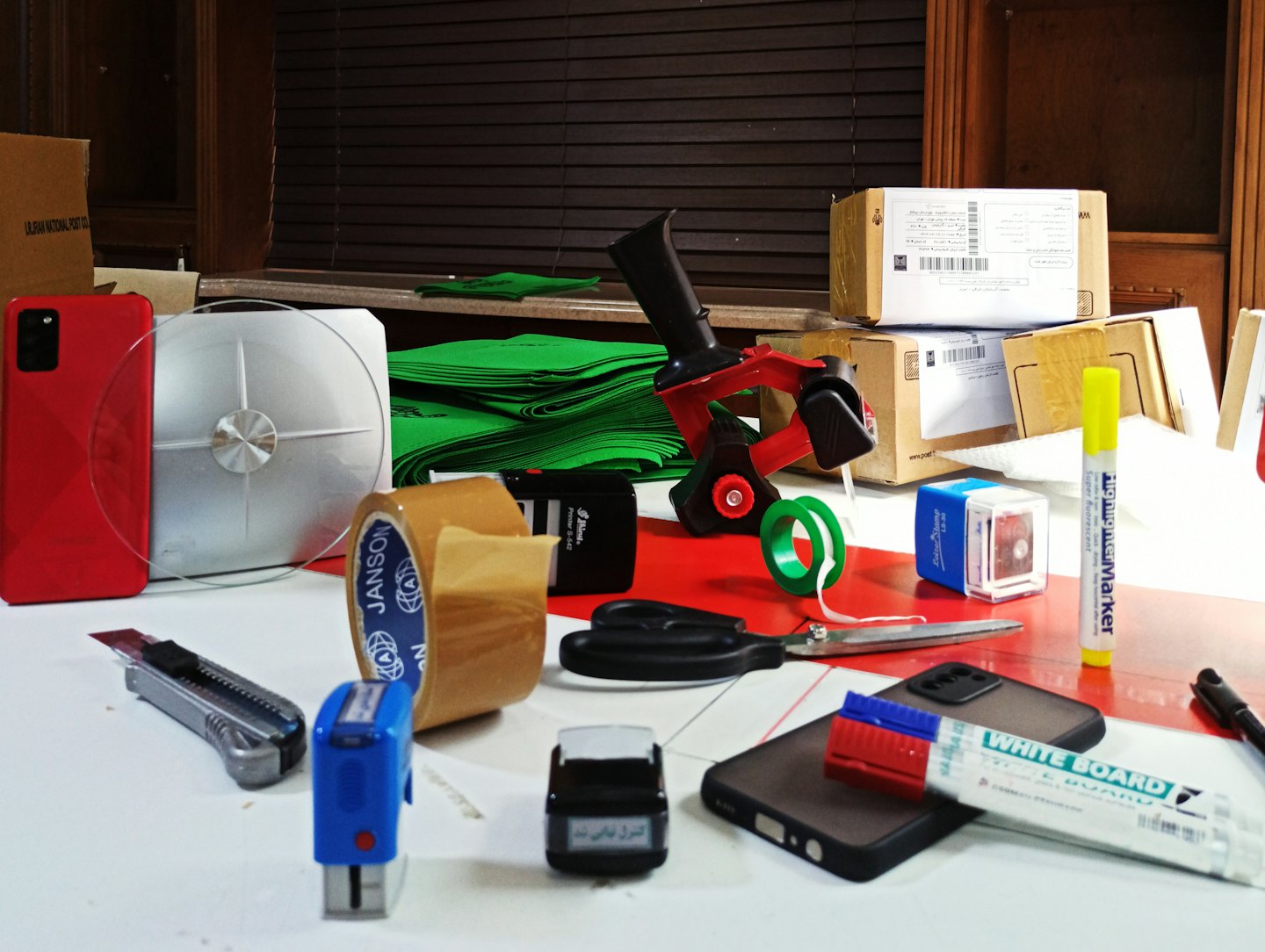 Shipping supplies on a white table with boxes in the background.